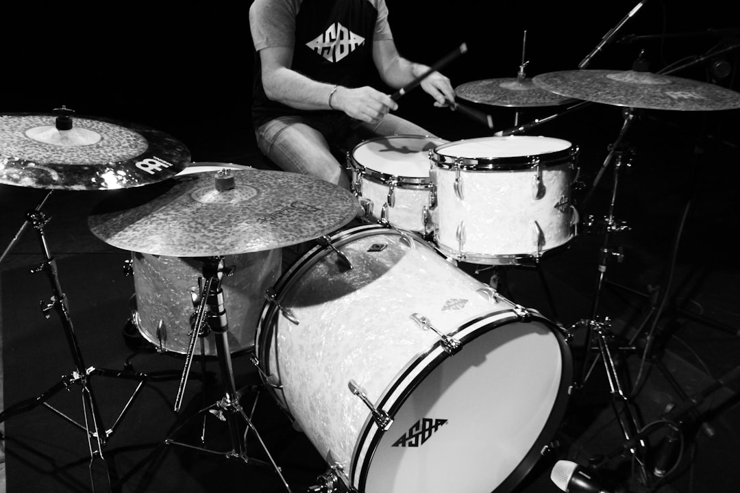 grayscale photo of man playing drum