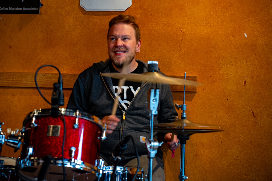 A man sitting behind a drum set in a recording studio